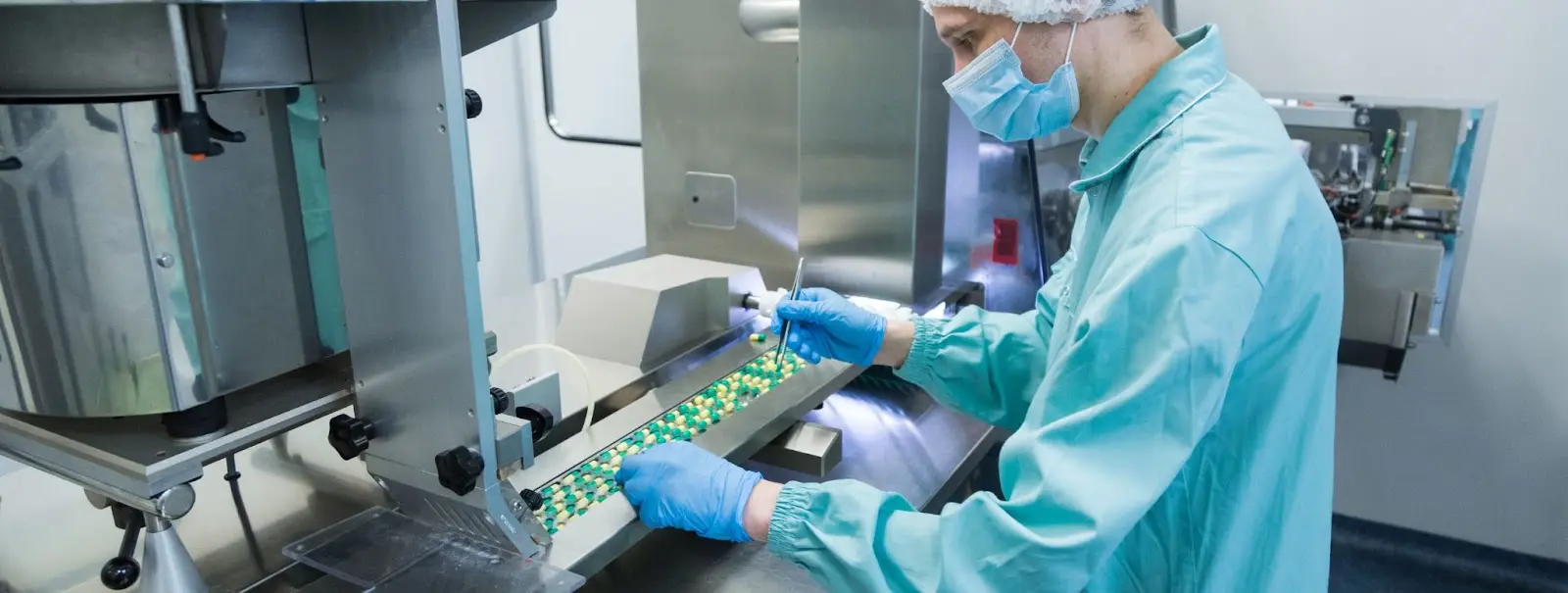 A man oversees the production of pharmaceutical tablets